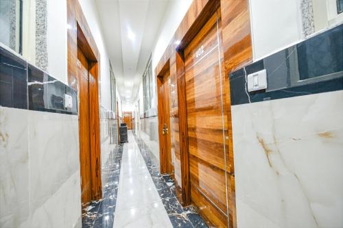 ein Flur mit Holztüren und Marmorwänden in der Unterkunft FabHotel Vihaan Regency in Neu-Delhi