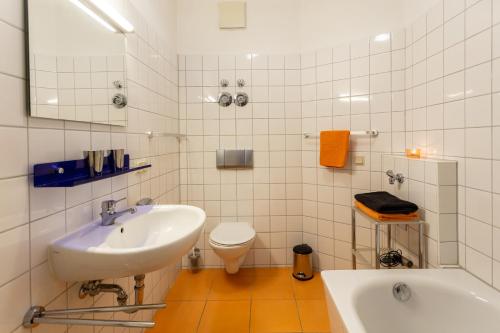 a white bathroom with a sink and a toilet at Gemütliches kleines Apartment in Dresden
