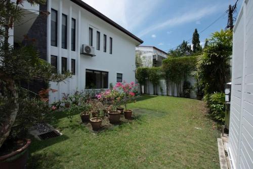 une cour avec des plantes en pot à côté d'un bâtiment blanc dans l'établissement KLCC Luxury Private Pool Villa, à Ampang