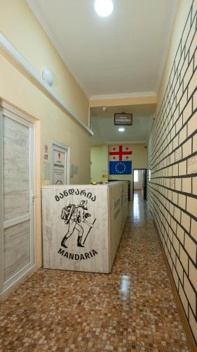 a hallway with a wall with a sign on it at Hostel Mandaria in Kutaisi