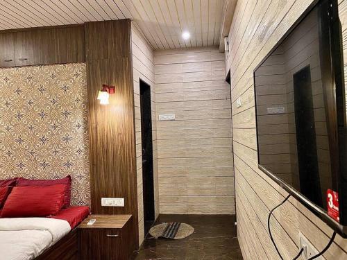 Cette petite chambre comprend un lit et une télévision. dans l'établissement Imagine Harmony, à Lonavala