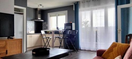Il comprend un salon avec une cuisine équipée d'une table et de chaises. dans l'établissement Appartement Pau, à Pau
