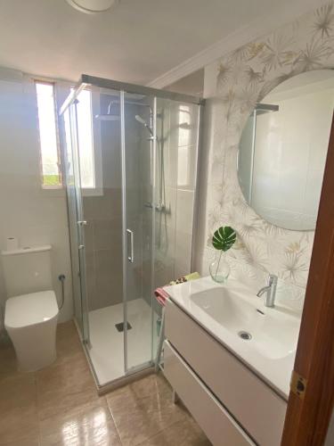 uma casa de banho com um chuveiro, um lavatório e um WC. em Sunrise beach em Santa Pola