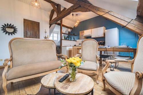 a living room with chairs and a table with a vase of flowers at Le Meslier - Appartement de 2 chambres in Tours-sur-Marne