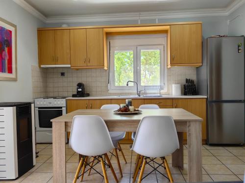 a kitchen with a wooden table and white chairs at Nina Apartment in Chania Town