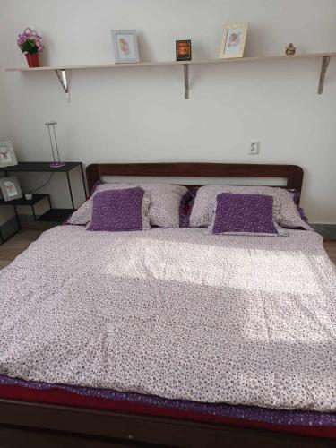 - une chambre avec un grand lit et des oreillers violets dans l'établissement APARTMAN OLOMOUC 2KK, à Olomouc