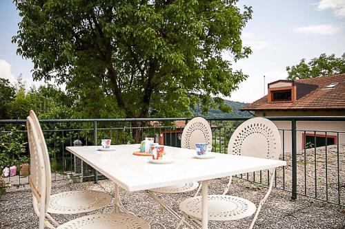 einen weißen Tisch und Stühle auf einer Terrasse in der Unterkunft Ferienwohnung für 4 Personen ca 65 m in Pisano, Piemont Lago Maggiore in Pisano