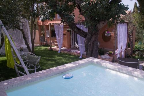 a pool with a rock in the middle of a yard at Unterkunft CASA MARC RUHIGES HAUS INSELZENTRUM in Vilafranca de Bonany