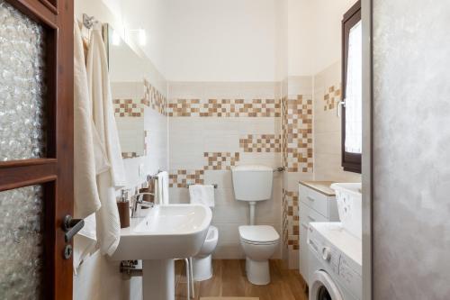 La salle de bains blanche est pourvue d'un lavabo et de toilettes. dans l'établissement Ca' Graziosi Fiori, à Bagnone
