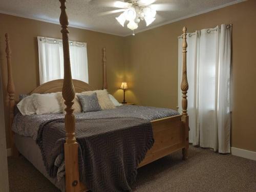 a bedroom with a bed with a wooden bed frame at Quiet Country Small Family Home 5 minutes from town in Mansura
