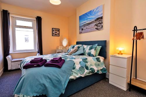 a bedroom with a bed and a window at Finest Retreats - Byron Street in Amble