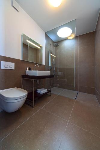 a bathroom with a toilet and a sink and a shower at Golden Rays Luxury Villas & Apartments in Primošten