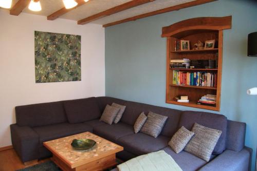 a living room with a couch and a book shelf at Jut Stuff - Familienfreundliche Wohnung in Rommersheim mit großem Garten in Rommersheim