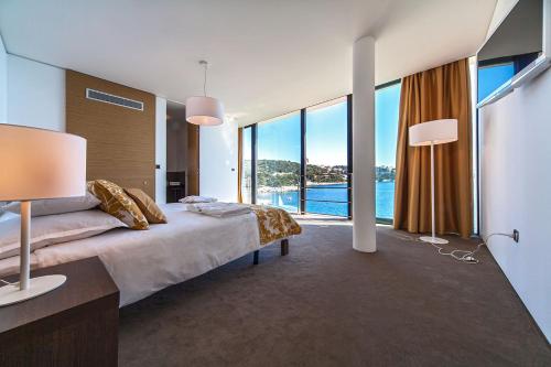 ein Schlafzimmer mit einem großen Bett und einem großen Fenster in der Unterkunft Golden Rays Luxury Villas & Apartments in Primošten