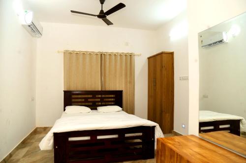 1 dormitorio con 1 cama y ventilador de techo en shoreline homestay, en Kozhikode