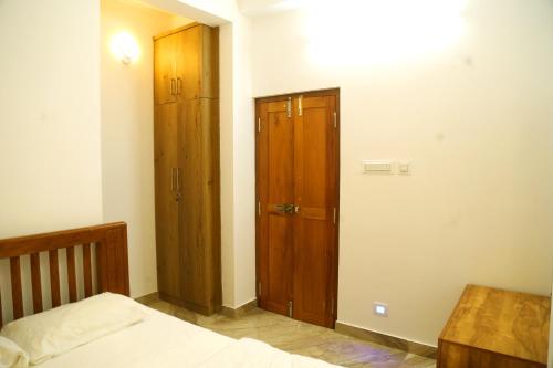 1 dormitorio con 1 cama y armario de madera en shoreline homestay, en Kozhikode