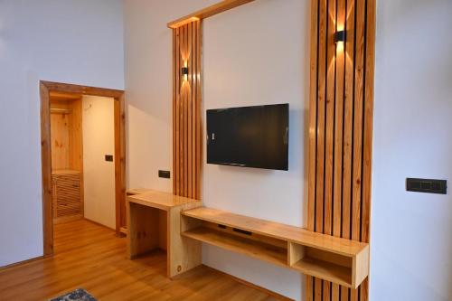 a living room with a tv on a wall at Silver fern by the Hillside in Nainital