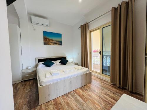 - une chambre avec un lit et une grande fenêtre dans l'établissement Villa Kanto (Holiday apartments and rooms), à Vlorë
