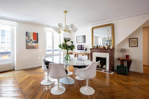 - un salon avec une table, des chaises et un miroir dans l'établissement Veeve - Chic By Bonne-Nouvelle, à Paris