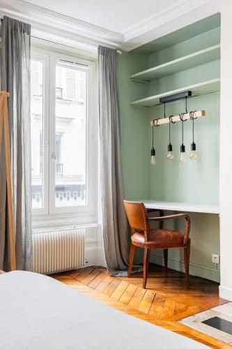 - une chambre avec un bureau et une chaise à côté d'une fenêtre dans l'établissement Veeve - Chic By Bonne-Nouvelle, à Paris