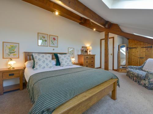 a bedroom with a large bed and a chair at Valley View in Barnstaple
