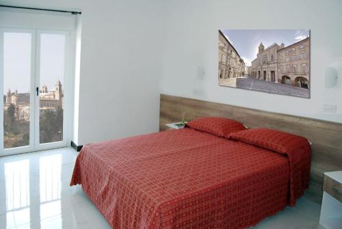 Un dormitorio con una cama roja con una foto en la pared en Ferienwohnung für 4 Personen ca 45 qm in Offida, Adriaküste Italien Küste der Marken, en Offida