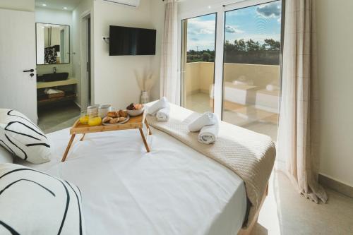 a bedroom with a bed and a table with food on it at Aiolia Villa in Lachania