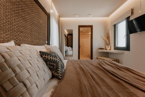 een slaapkamer met een groot bed en een groot raam bij ONYM Curated Villas in Plaka