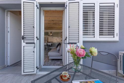un jarrón de flores sobre una mesa de cristal en un balcón en Casa Gemma Comfortable Apartment, en Bolonia