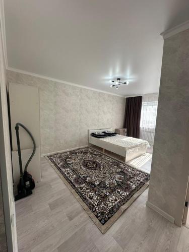 a white room with a bed and a rug at Квартира in Aktau