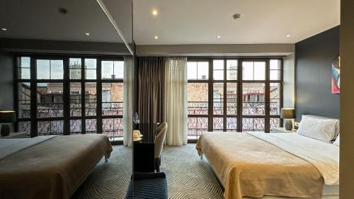a hotel room with two beds and a balcony at Silver 39 Corner Hotel in Tbilisi City