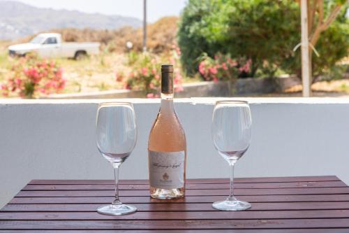 a bottle of wine and two wine glasses on a table at Golden Sand in Plaka