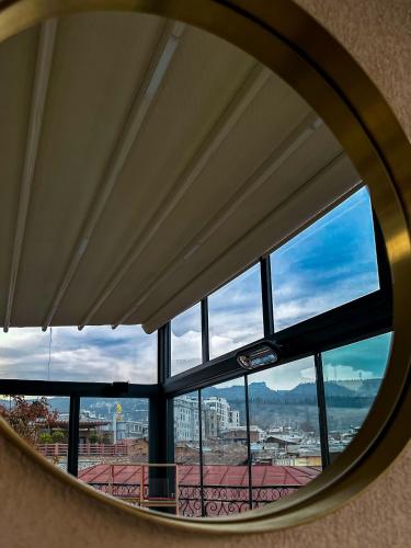 a round window with a view of a city at Silver 39 Corner Hotel in Tbilisi City