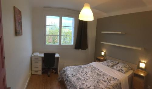 a bedroom with a bed and a desk and a window at Bel appartement à Dijon 2 in Dijon