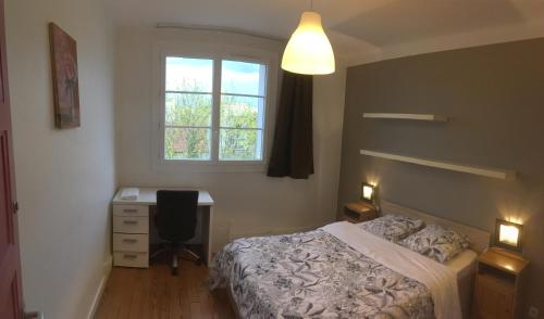 une chambre avec un lit, un bureau et une fenêtre dans l'établissement Bel appartement à Dijon 2, à Dijon