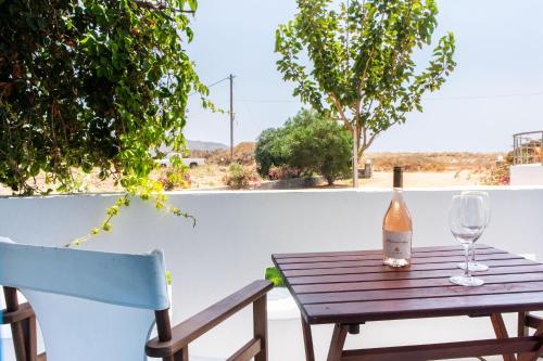 a table with a bottle of wine and a glass at Golden Sand in Plaka