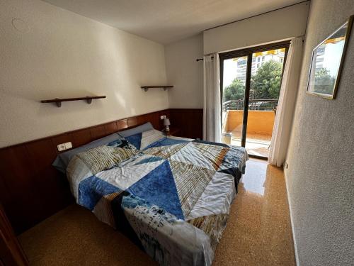 ein Schlafzimmer mit einem Bett und einem großen Fenster in der Unterkunft PV34, Apartamento cerca mar con piscina parking in Villajoyosa