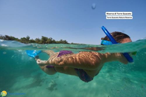 a person in the water with a snorkel at La Casa di Vivì vicino al mare in Specchiolla 