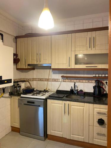 a kitchen with white cabinets and a stove top oven at Kiralık in Istanbul