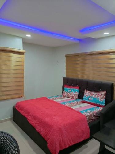 een slaapkamer met een bed met een rode deken bij Blue Lagoon Hotel in Lagos