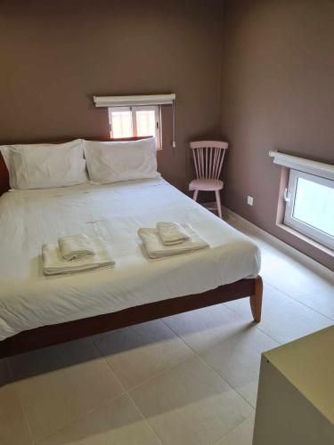 a bedroom with a large bed with two towels on it at Casa Limo in São Martinho do Porto