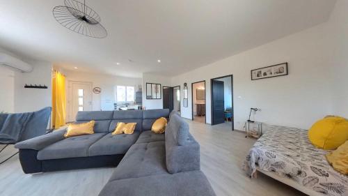 - un salon avec un canapé bleu et un lit dans l'établissement Spacious 2 bedroom Apartment with Garden Near Pezenas, à Nézignan-lʼÉvêque