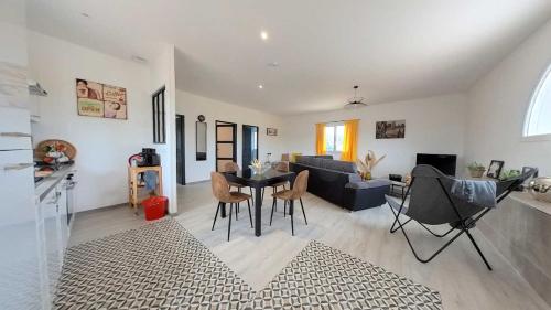 un salon avec un canapé, une table et des chaises dans l'établissement Spacious 2 bedroom Apartment with Garden Near Pezenas, à Nézignan-lʼÉvêque
