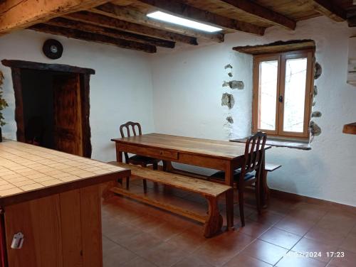 a dining room with a wooden table and chairs at Roseland, retraite calme en pleine nature in Saint-Girons