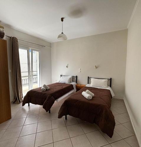 a bedroom with two beds with brown blankets at Imerolia Studios in Kassiopi