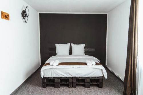 a bedroom with a bed with white sheets and pillows at Casa Rosu in Cluj-Napoca