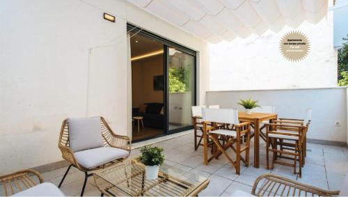 a patio with a wooden table and chairs at Magno Apartments San Martín Terrace in Seville