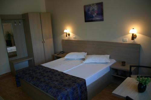 a bedroom with a large bed with two pillows at Hotel Regal in Eforie Nord