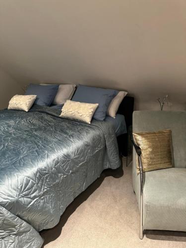 ein Schlafzimmer mit einem Bett und einem Stuhl in der Unterkunft Elegance Hamont in Hamont