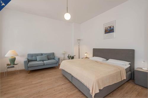 sypialnia z łóżkiem i niebieską kanapą w obiekcie Apartment Martha 3 w mieście Heringsdorf